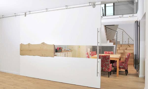 Große weiße Schiebewand an Deckenschiene vor einem Essbereich
