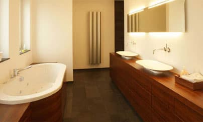 Badezimmer mit Eckbadewanne, Doppelwaschtisch aus Nussbaum und Schieferboden