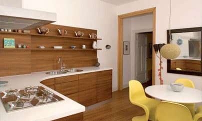 Wohnküche mit geschwungener Nussbaumfront, weißer Corian-Arbeitsplatte und offenen Regalböden