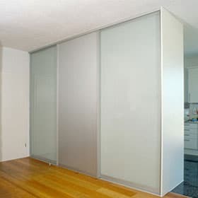 Raumteiler mit satinierten Glas-Gleittüren zwischen Wohnraum und Küche