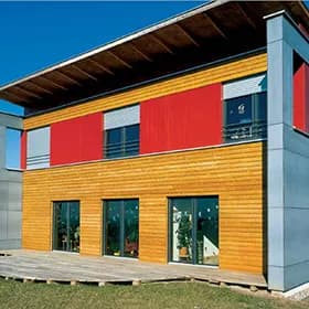 Modernes Wohnhaus mit orange-roter Holzfassade und großen Fensterflächen