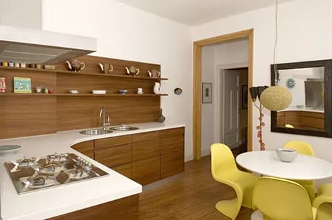 Moderne Küche mit Holzfronten, weißer Arbeitsplatte und gelben Stühlen am Esstisch
